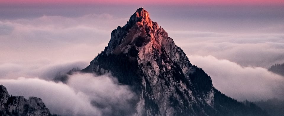 A mountain peak above the clouds at sunrise