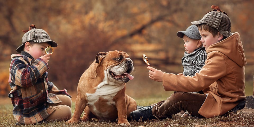 Three children in detective costumes with an English bulldog