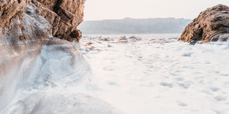 Sunlit rocks on a frozen shore
